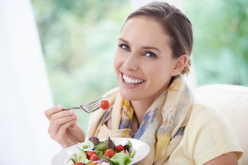 Image showing Woman, smile and eating salad in home for diet, health and wellness with pride at lunch in lounge. Person, food and hungry with vegetables, plate and nutrition with vitamins, fiber and relax in house