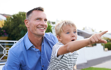 Image showing Bonding, father and child in garden pointing with excited, smile and outdoor view in backyard. Happy man, son and quality time together in neighborhood with learning, discovery and support from dad.