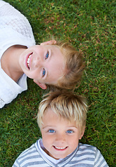 Image showing Smile, portrait of girl and boy on grass together for bonding, outdoor fun and kids from above. Happiness, lawn and face of children in backyard on weekend for playful development, growth and care.