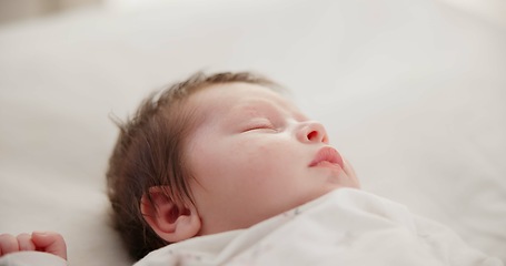 Image showing Baby, face and sleeping in the morning on nursery bed and blanket with nap and rest. Relax, calm and tired newborn with youth on bedding with kid sleeping from above in a family home and bedroom