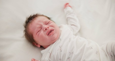 Image showing Newborn, face and sleeping with dream on bed in nursery for relaxing or resting with child development. Baby, tired and waking up in bedroom of house with calm, relax and cute infant in family home