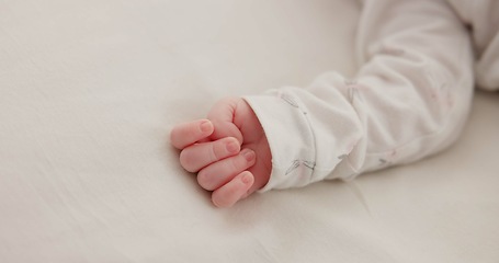 Image showing Hand, baby and sleeping on bed in nursery for child development, childcare and nurture in home. Newborn, resting or relaxing in bedroom with rest, dreaming or closeup for wellness and health in house