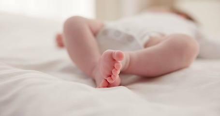 Image showing Sleeping, family and feet of baby on bed for child care, dreaming and relax in nursery. Adorable, cute and closeup of toes of innocent newborn infant for health, wellness and development at home