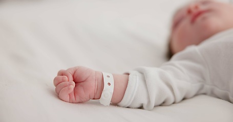 Image showing Baby, new born and hand with bracelet on bed for care, trust or support in hospital for birth. Infant, love and hope with child development for future growth in family home, protection and security