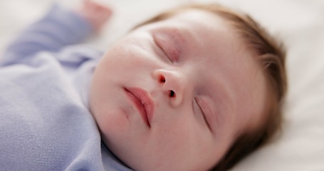 Image showing Face, growth and sleep with a baby on a bed closeup in a home, dreaming during a nap for child development. Relax, calm and rest with an adorable newborn infant asleep in a bedroom for comfort