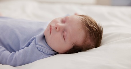 Image showing Relax, growth and sleep with a baby on a bed closeup in a home, dreaming during a nap for child development. Kids, calm and rest with an adorable newborn infant asleep in a bedroom for comfort