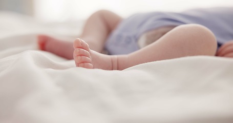 Image showing Sleeping, dreaming and feet of baby on bed for child care, resting and relax in nursery. Adorable, cute and closeup of toes of innocent newborn infant for health, wellness and development at home