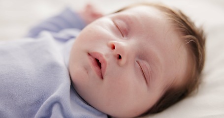 Image showing Face, relax and sleep with a baby on a bed closeup in a home, dreaming during a nap for child development. Growth, calm and rest with an adorable newborn infant asleep in a bedroom for comfort