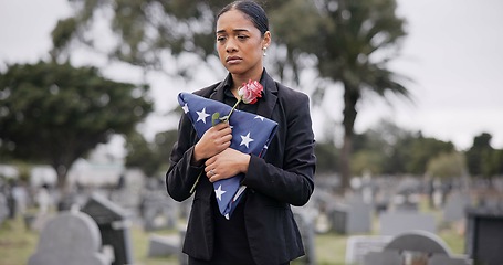 Image showing Funeral, rose and american flag with a woman at a cemetery in mourning at a memorial service. Sad, usa and an army wife as the widow of a patriot in a graveyard, feeling pain of death, loss or grief