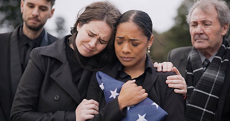 Image showing Funeral, death and support for a woman with a flag at a cemetery in mourning at a memorial service. Sad, usa and an army wife as a widow in a graveyard feeling the pain of loss or grief with a friend