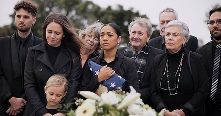 Image showing Funeral, cemetery and family with American flag for veteran for respect, ceremony and memorial service. Sad, depression and people by coffin in graveyard for military hero, army and soldier mourning