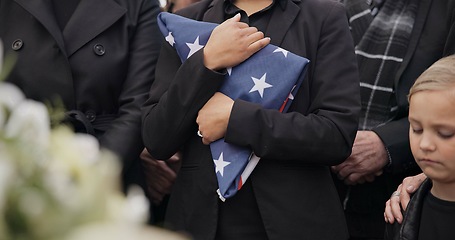 Image showing Funeral, cemetery and woman with American flag for veteran for respect, ceremony and memorial service. Family, depression and sad people by coffin in graveyard for military, army and soldier mourning