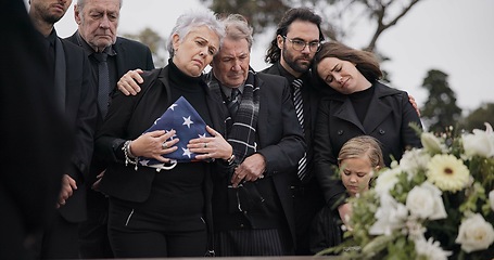 Image showing Funeral, cemetery and family with American flag for soldier for respect, ceremony and memorial service. Sad, depression and people by coffin in graveyard mourning military, army and veteran hero