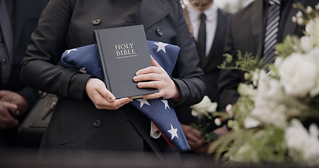 Image showing Hands, american flag and bible with a person at a funeral, grieving a loss at a graveyard. War, cemetery and death with an army wife at a memorial service to say goodbye to a fallen soldier closeup