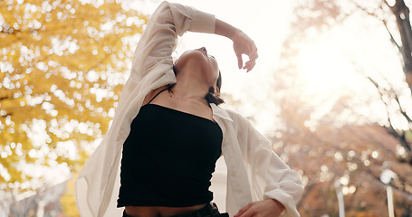 Image showing Japanese woman, trees and dancing in park, moving body and freedom for street performance in nature. Girl, dancer and person with art, concert and steps with creativity, face and balance in Tokyo