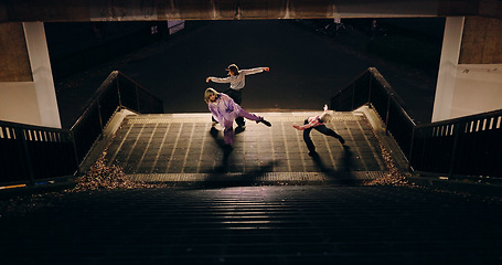 Image showing Women, group and dancing on stairs in city, moving body and freedom for street performance in night. Team, dancer or people with art, concert and steps with creativity, vision and balance in Tokyo