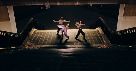 Image showing Women, group and dancing on stairs in city, moving body and freedom for street performance in night. Team, dancer or people with art, concert and steps with creativity, vision and balance in Tokyo