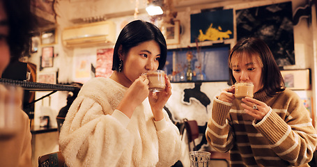 Image showing Japanese friends, cheers and coffee in restaurant for dinner, vacation and hot drinks to celebrate on holiday. Women, man and happy together at supper in tokyo city and cappucino by bonding in cafe