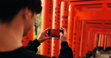 Image showing Phone, man and picture of torii gates on vacation, holiday trip or travel for tourism. Smartphone, hands and closeup photography of Fushimi inari-taisha in Kyoto Japan on mobile technology outdoor