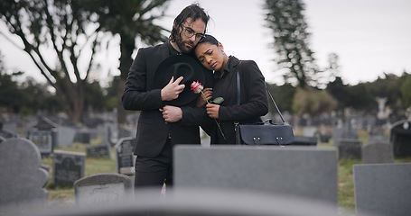 Image showing Couple, sad and mourning at tomb of graveyard, funeral and pay respect together outdoor. Death, grief and man and woman at cemetery by casket, empathy and interracial support to console at tombstone