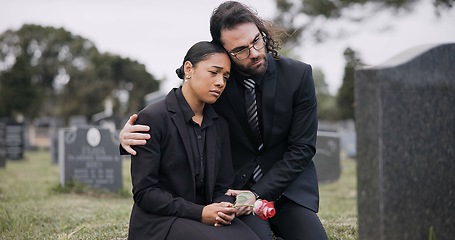 Image showing Sad couple, rose and graveyard in loss, grief or mourning at funeral, tombstone or cemetery. Man and woman hug with flower in depression, death or goodbye at memorial or burial service for loved one