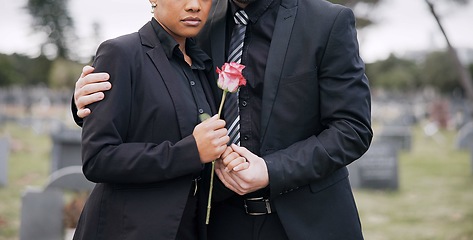 Image showing Rose, death or couple in cemetery for funeral. spiritual service or burial to repsect the Christian religion. Mourning, depressed or sad people hug in graveyard for grief, loss or goodbye farewell