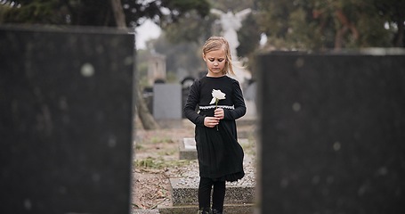 Image showing Sad, death or kid in cemetery for funeral. spiritual service or grave visit for respect in Christian religion. Mourning, tomb or depressed girl child outside in graveyard for grief, loss or farewell