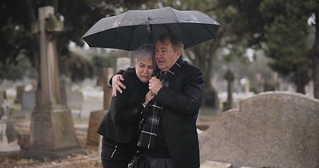 Image showing Support, death or old couple in cemetery for funeral, service or burial for repsect in Christian religion. Umbrella, depressed or sad senior people hug for comfort in graveyard crying in mourning