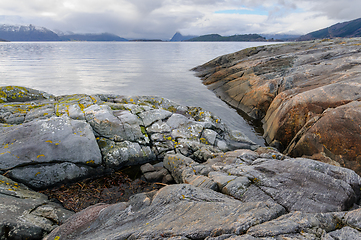 Image showing Tranquil view of the sea with rocky coastline and distant mounta