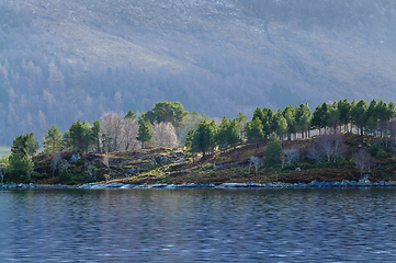 Image showing Serene sea view with forested hillside and misty mountains at da