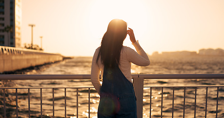 Image showing Back, woman and sea with sunset and view of horizon outdoor, travel and tourism with peace, calm and nature. Environment, ocean and traveller on adventure or journey, sunshine and wind in Kyoto