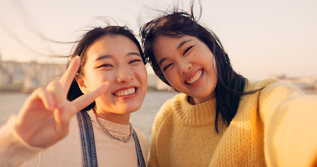 Image showing Women, friends and selfie at sea holiday in Japan for travel experience, adventure or happy. Female people, peace sign and face for city tour trip or online connection for summer, social or vacation