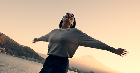 Image showing Japanese woman, freedom and happiness outdoor, lake or ocean with travel, holiday and mindfulness in nature. Wellness, adventure and care free at beach in Japan, smile with spinning and positivity