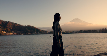 Image showing Woman, walking by river and nature with travel and journey outdoor, holiday or vacation with break. Environment, water and fresh air, traveller on adventure with peace, calm and wellness on trip