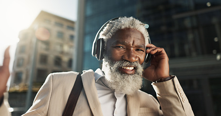 Image showing Happy, dancing and senior businessman with headphones in the city walking and listening to music. Smile, happy and elderly African male person streaming playlist, song or radio commuting in town.