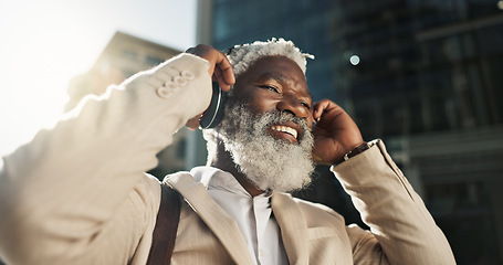 Image showing Happy, dancing and senior businessman with headphones in the city walking and listening to music. Smile, happy and elderly African male person streaming playlist, song or radio commuting in town.