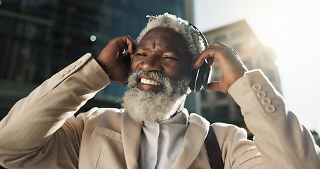 Image showing Happy, dancing and senior businessman with headphones in the city walking and listening to music. Smile, happy and elderly African male person streaming playlist, song or radio commuting in town.