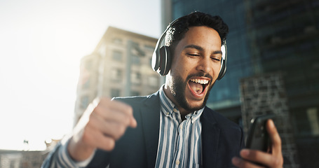 Image showing Happy, dance and businessman with headphones in city for job promotion celebration with phone. Smile, cellphone and excited professional young male person listening to music, radio or album in town.