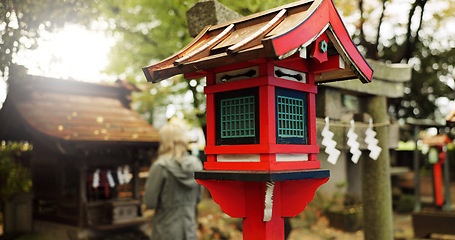 Image showing Japan, nature and wooden lantern in Kyoto with trees, tourist and woman with torii gate. Architecture, japanese culture and shinto shrine in woods with sculpture, religion memorial and monument