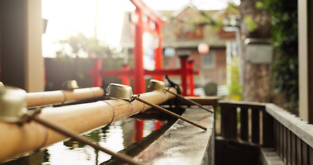 Image showing Shinto shrine, closeup and fountain with water in container for faith, cleaning and washing for wellness. Religion, culture and praise with purification ritual in woods, peace and temple in Kyoto