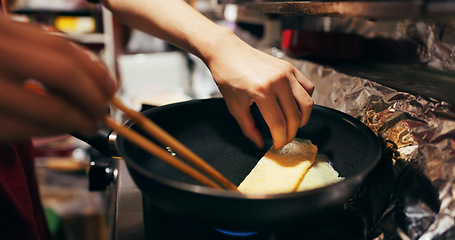 Image showing Cooking, chopsticks and person with egg in pan at market for frying food for meal preparation, eating and nutrition. Culinary, flame and closeup of chef prepare lunch, cuisine dinner and supper