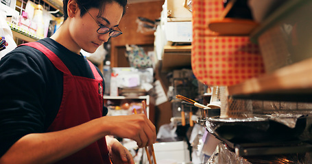 Image showing Japanese chef man, cooking and chopsticks by stove, service or catering job on heat, flame or ready. Person, restaurant or cafeteria in kitchen for meal prep, working or thinking for recipe in Tokyo