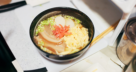 Image showing Ramen food, plate and table in restaurant with person, hands and ginger with closeup for Japanese cuisine. Niboshi bowl, chopsticks and pork for diet, nutrition and catering for wellness in Tokyo