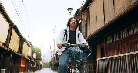 Image showing Bike, travel and man riding by building for exercise or transportation to college academy. Fitness, backpack and young male student driving a bicycle to university for carbon footprint by houses.