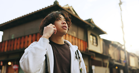 Image showing Man, phonecall and outdoor in japan, lost and looking for directions in kyoto, standing and alone. Houses, japanese and cellphone for travelling, tourist and sightseeing and view with mobile