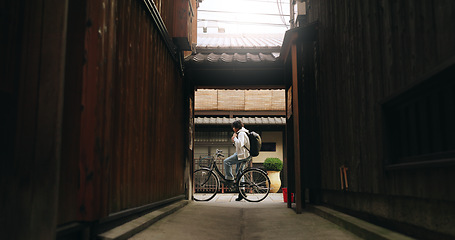 Image showing Bicycle, travel and man riding by building for exercise or transportation to college academy. Fitness, backpack and young male student driving a bike to university for carbon footprint by houses.