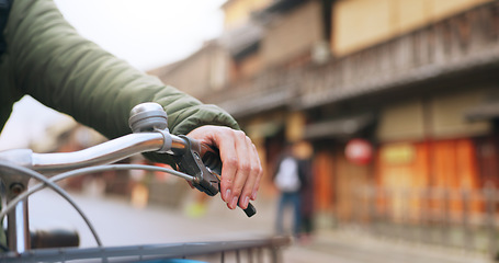 Image showing Hands, bicycle and brake handle in street, travel and transport outdoor of active rider on urban road for health. Closeup, press handlebar and person cycling to control or check bike in Kyoto Japan