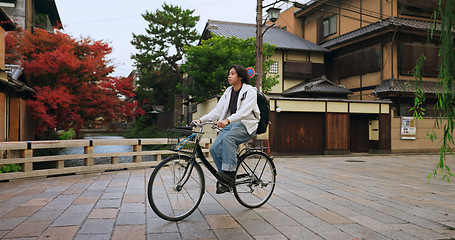 Image showing Cycling, travel and man riding by buildings for exercise or transportation to college academy. Fitness, backpack and young male student driving a bicycle to university for carbon footprint by houses.