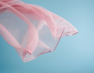 Image showing Flying pink fabric wave on blue background, flowing waving silk 