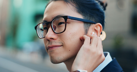 Image showing Business man, city and listening to music, digital podcast and streaming audio connection with earphones. Face, Japanese employee and thinking of sound for radio subscription in urban street in Tokyo